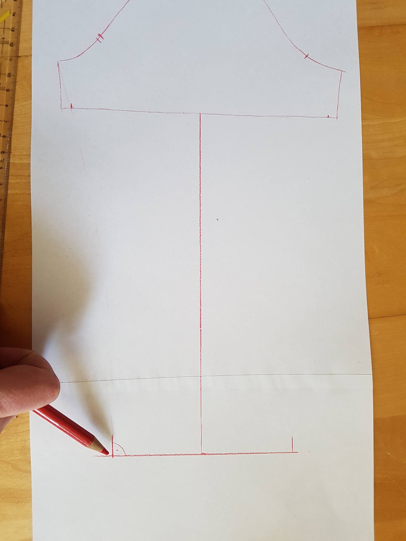 Am Ende der neuen Linie eine rechtwinklige Linie ziehen, und rechts uns links von der Mitte jeweils die halbe Ärmelsaumweite markieren