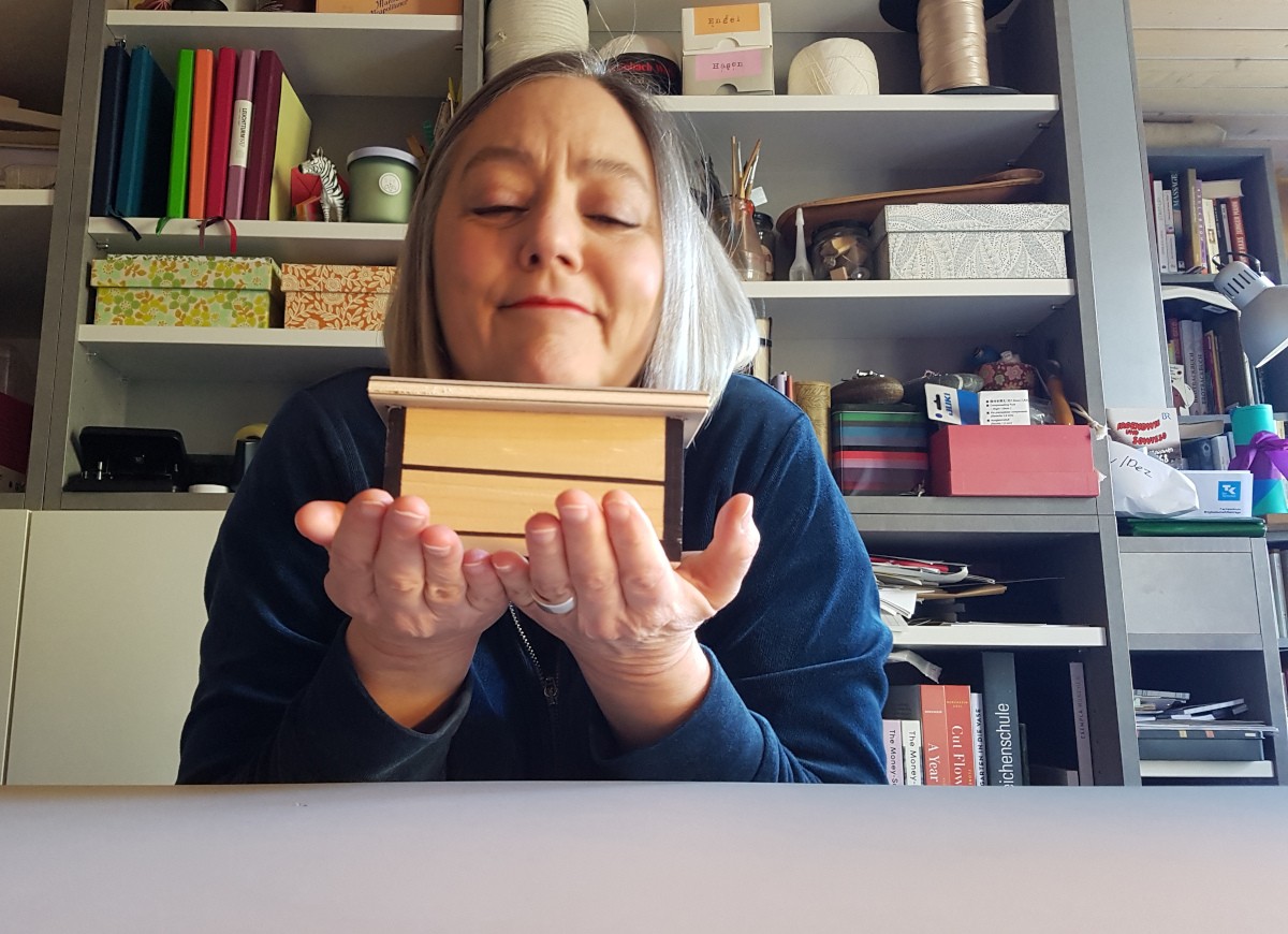 Sabine hält den kleinen Modelltisch in der Hand und schaut ganz verliebt aus.