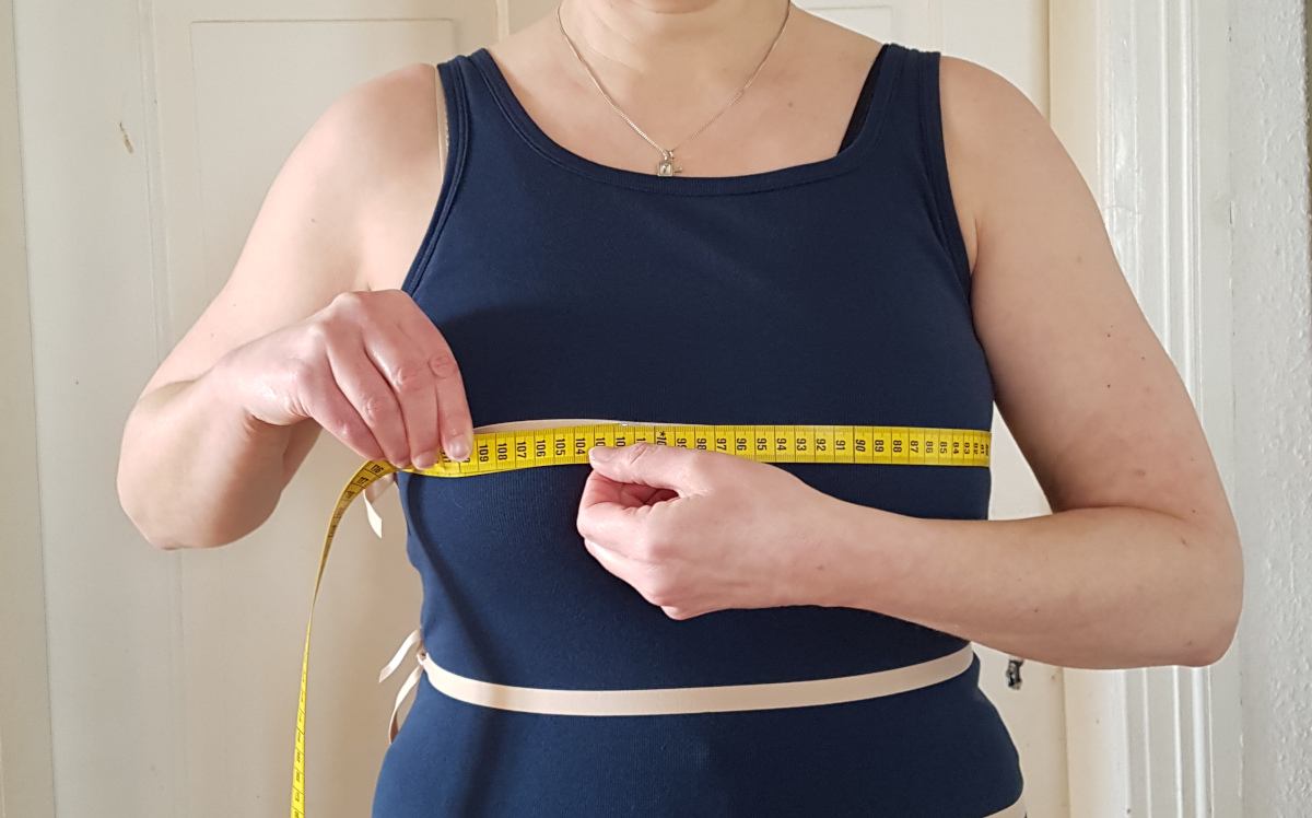 Brustumfang messen Bildausschnitt, das Massband liegt um den Brustumfang