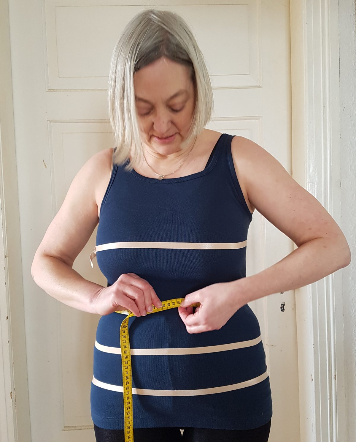 Taillenumfang messen Sabine schaut nach unten und liest das Maß des Taillenumfangs ab