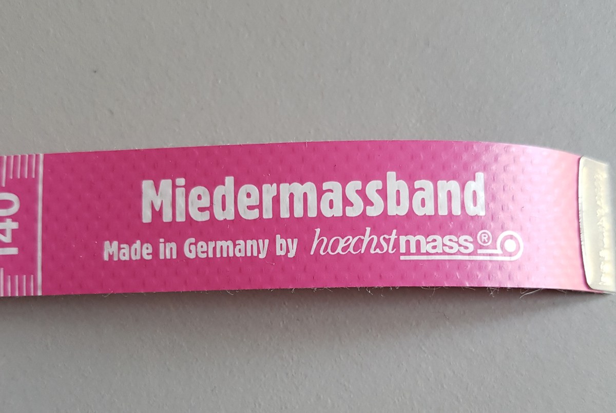 Ausschnitt aus dem pinken Maßband mit der Aufschrift "Miedermaßband"